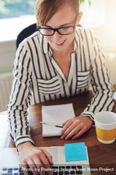 Content female in striped shirt with coffee working on laptop at her desk bDBeA5
