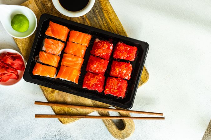 Top view of box of salmon & tuna sushi rolls