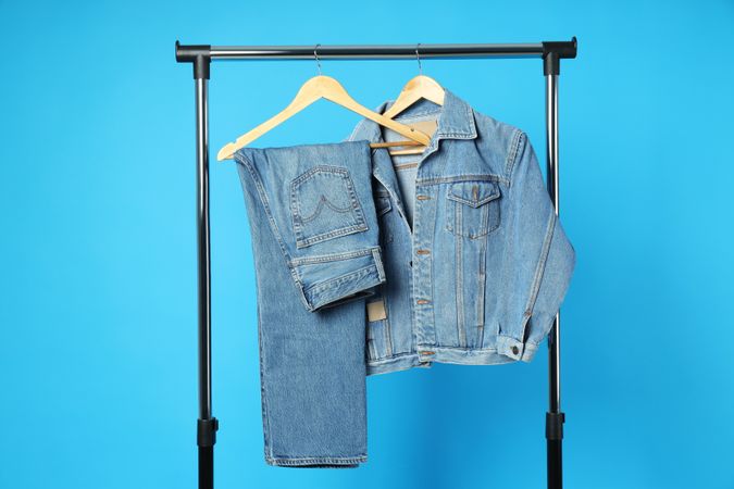 Jeans hang on hangers on a blue background