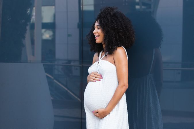 Smiling pregnant woman in long dress