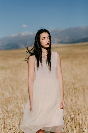 Model in dress standing in field