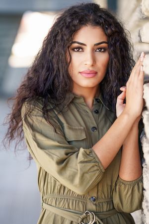 Middle Eastern woman resting on outside wall