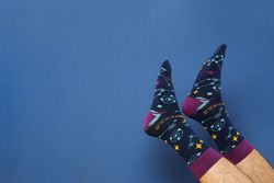 Male legs in socks on blue background, space for text
