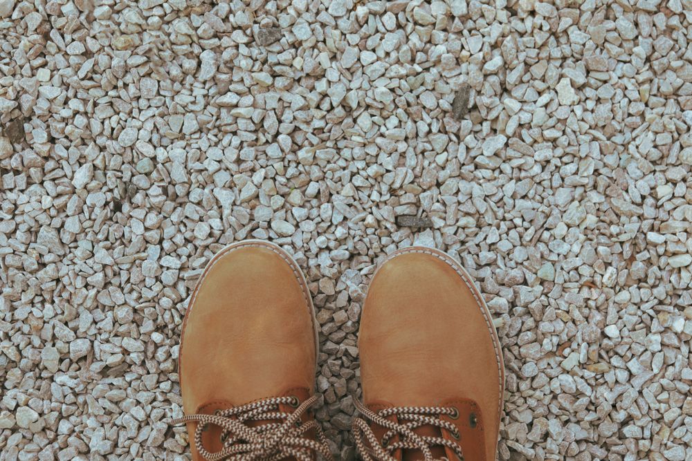 Boots on stones background, top view and space for text