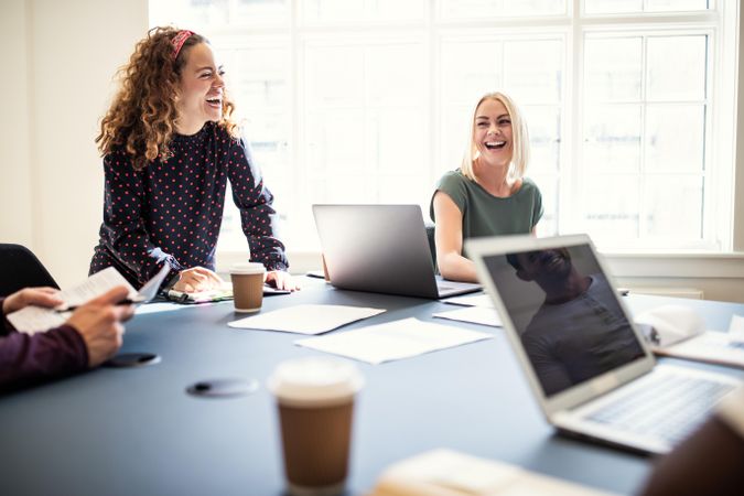 Two woman smiling in a meeting in a casual office