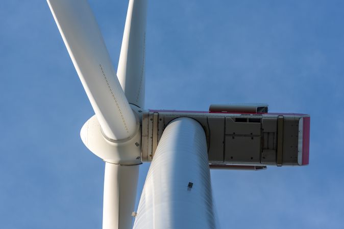 Modern wind turbine close-up, isolated on the blue sky, low angle view