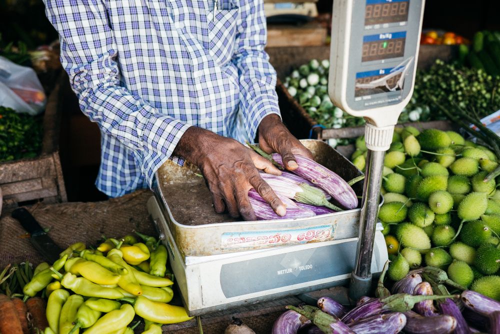 Vendor weighing fresh vegetables at Sri Lankan market