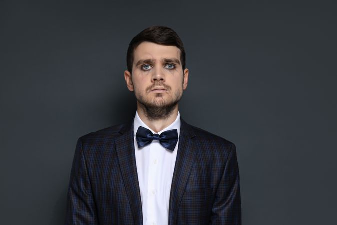 A man in a zombie costume on a dark background