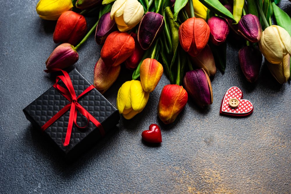 Top view of counter with tulips, hearts and wrapped presents 