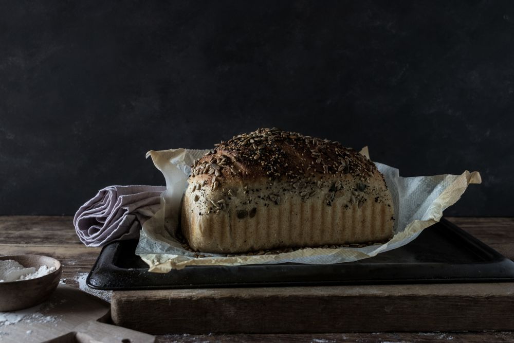 Fresh bread with wheat grains on tray