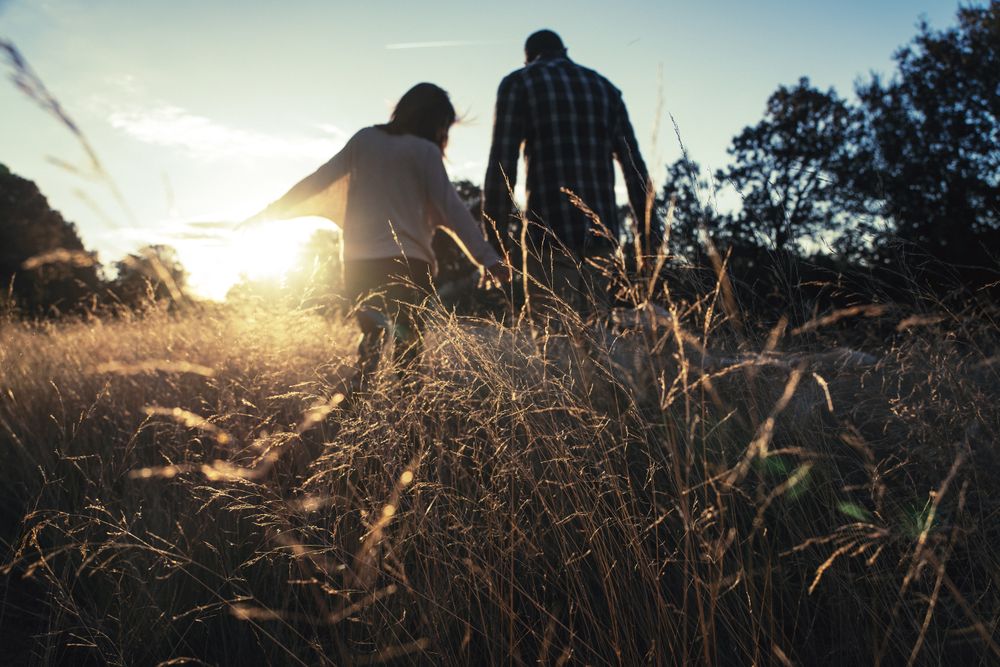 Loving couple walking in golden rural field