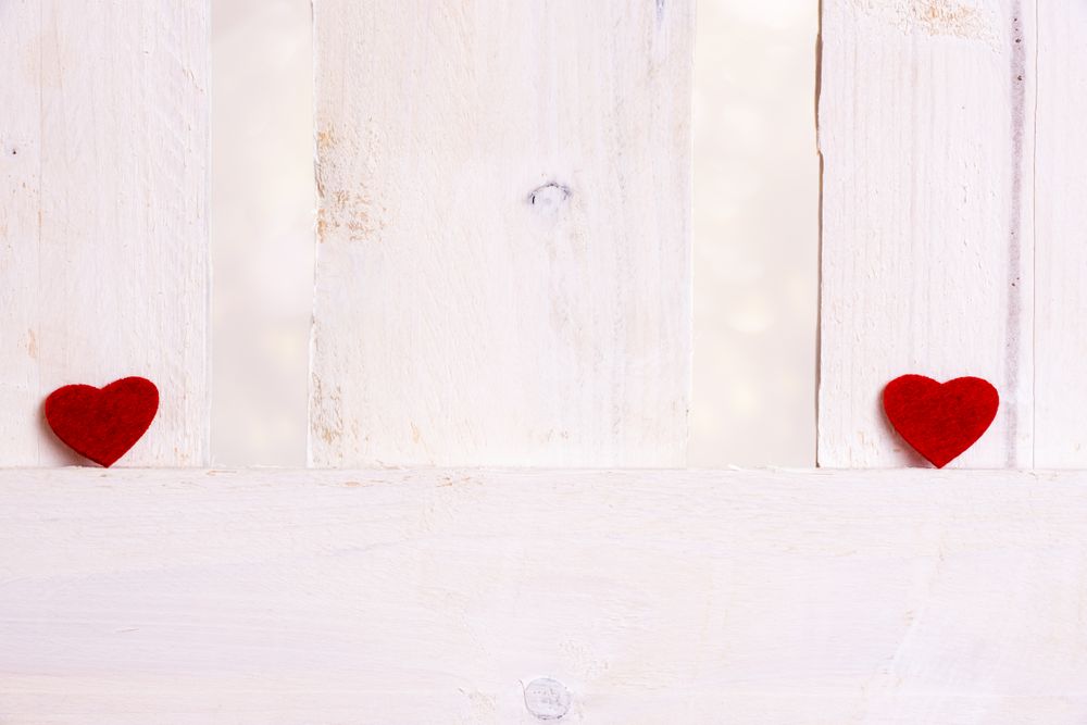 Red hearts apart on a fence