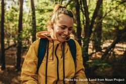 Female camper smiling standing in a forest 5q18q5
