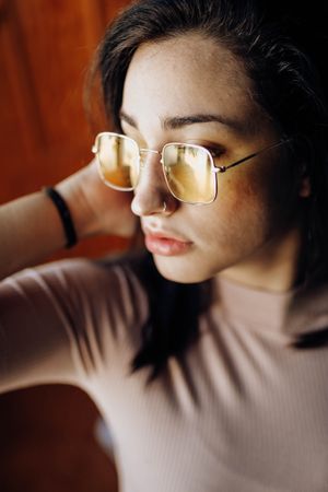 young woman portrait with yellow glasses posing