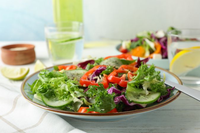 Fresh salad in plate on light background, close up