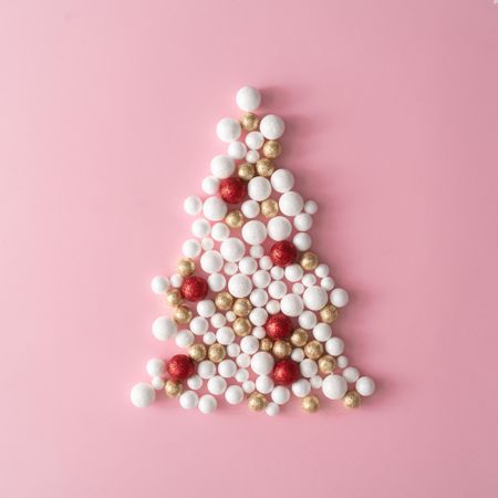 Christmas tree made of gold and red glitter ball decoration on pink