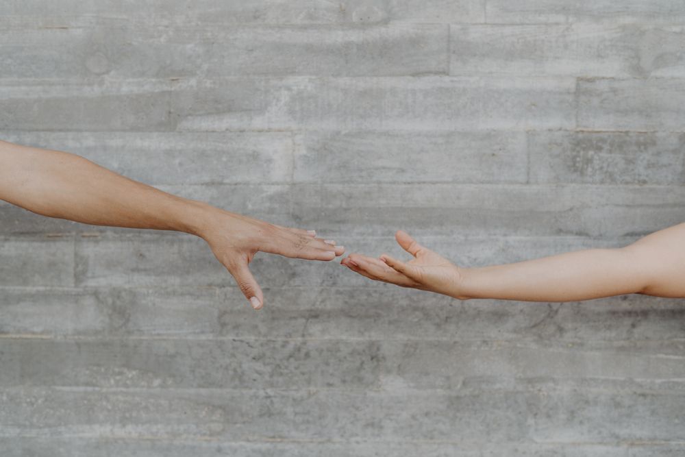 Hands touching on background of grey wall