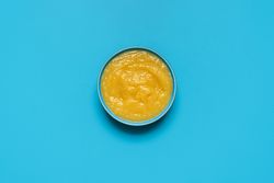 Apple sauce bowl above view, isolated on a blue background