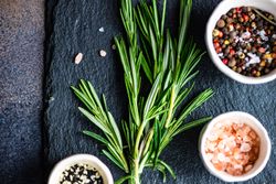 Top view of rosemary sprig on kitchen counter with seasoning