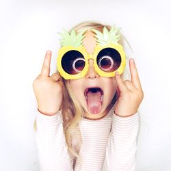 Blonde girl having fun wearing big pineapple sunglasses