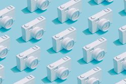Pattern composition of vintage cameras on pastel blue background