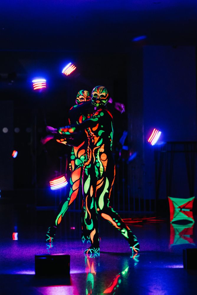 Two people with neon body paint performing on stage - Free Photo