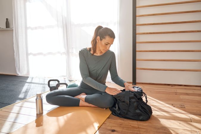 Person sitting on gym floor and preparing for training