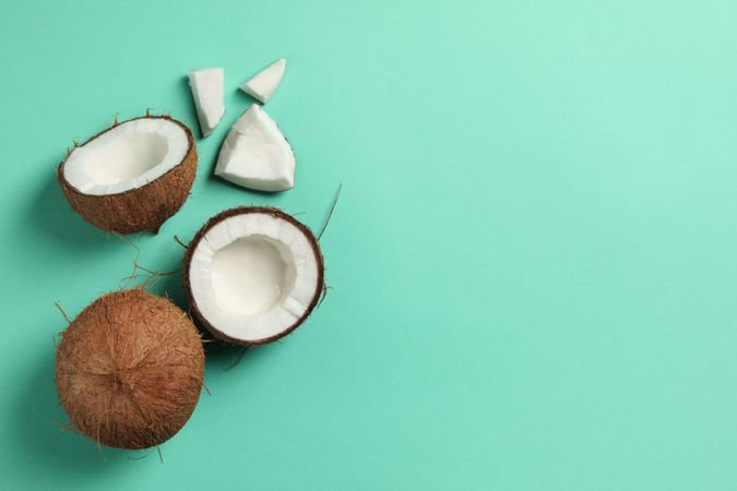 Coconut on mint background, top view and space for text