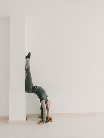 Flexible woman training upside down in studio