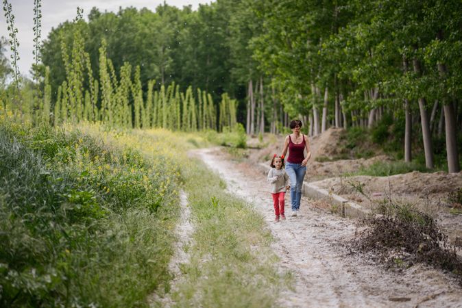 Woman and girl walking on trail in park