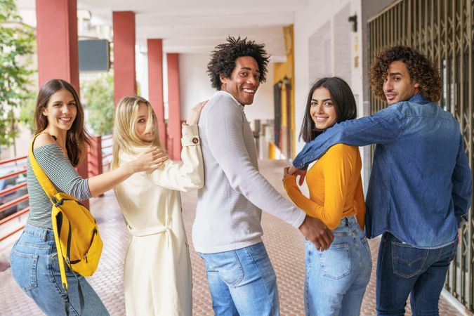 Group of young people turning around looking at camera and smiling