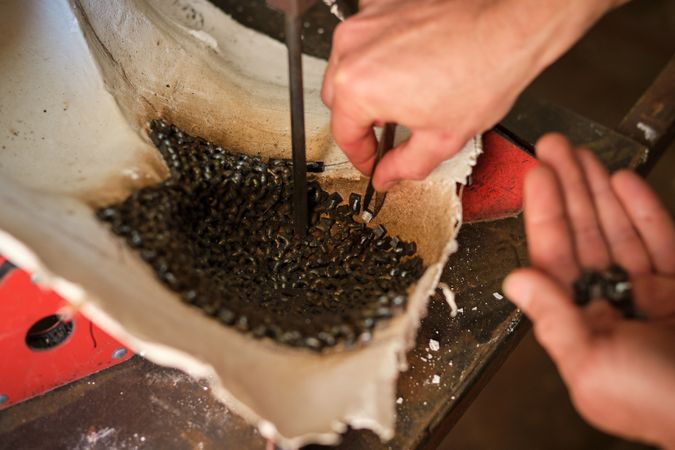 Unrecognizable artisan working on metal details in welding works