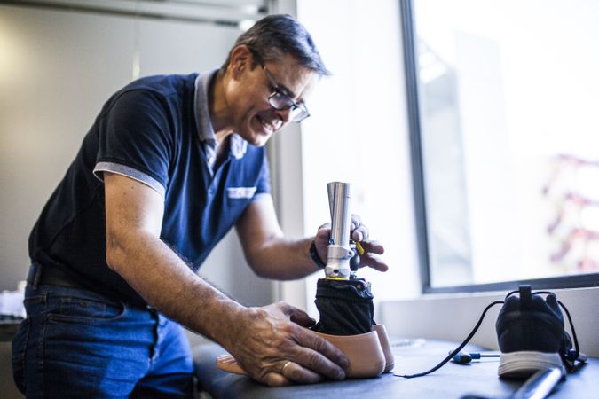 man fixing a prosthesis in a workshop