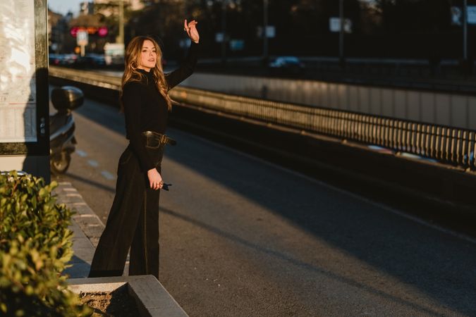 Cheerful woman hailing taxi