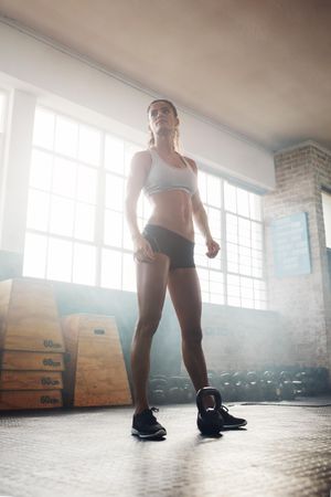 Fitness female model with kettle bell on floor