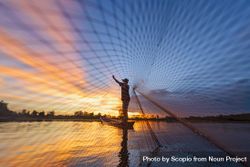 Fisherman throwing net into the ocean 0KQWY4