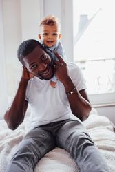 Baby boy on his fathers shoulders and smiling