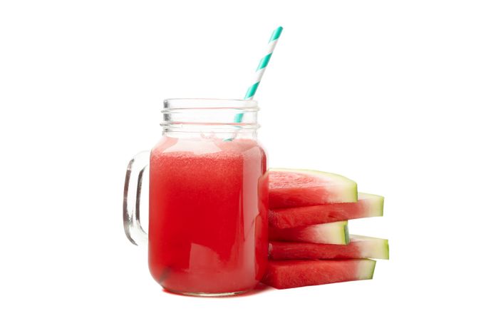 Glass jar of watermelon juice and slices isolated on blank background