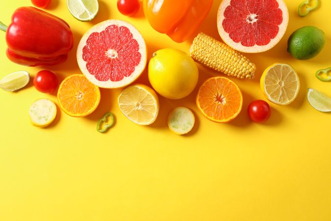 Different vegetables and fruits on yellow background, top view
