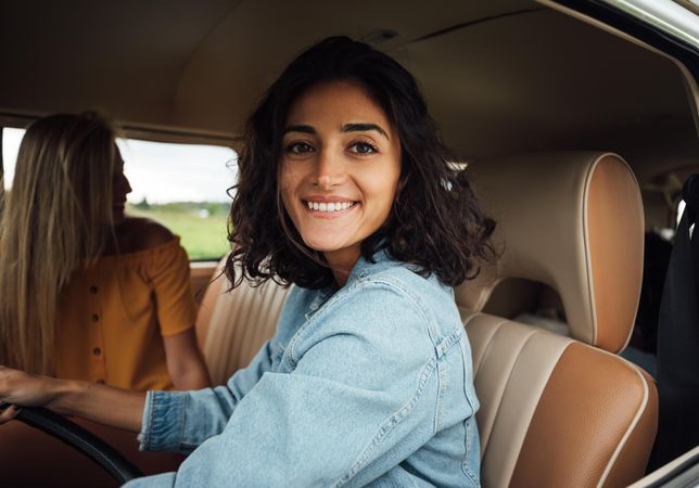 Happy woman in vehicle with friend in passenger seat