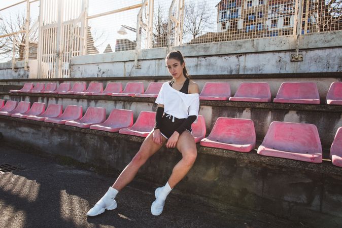 Young sportswoman resting on shabby seat