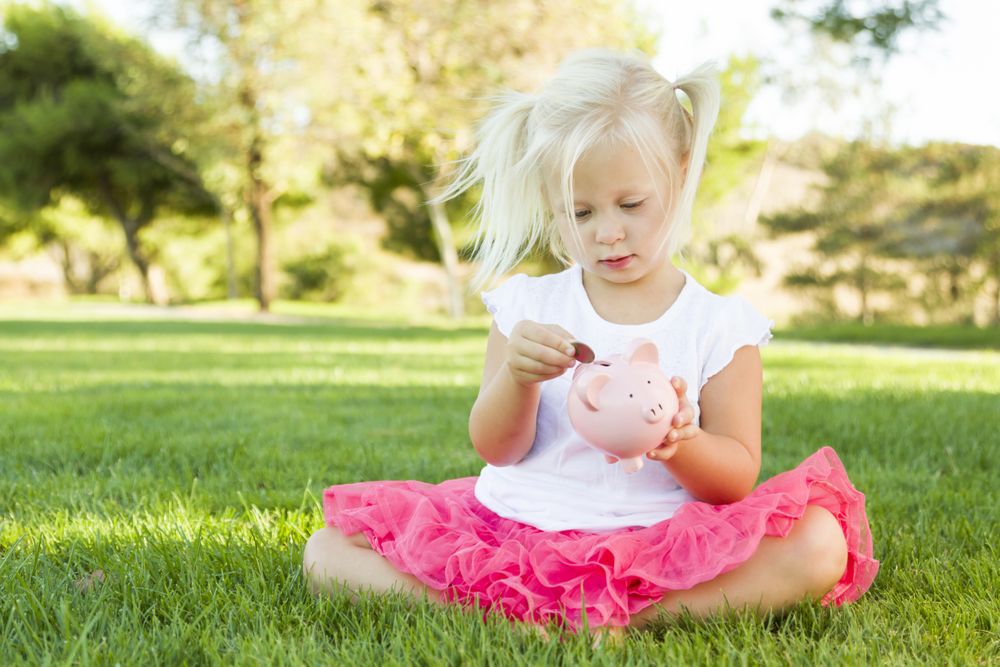 Little Girl Having Fun with Her Piggy Bank Outside