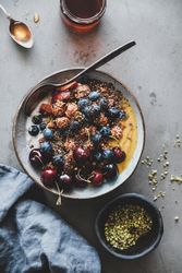 Oat granola yogurt bowl with cherries, blueberries, honey, nuts