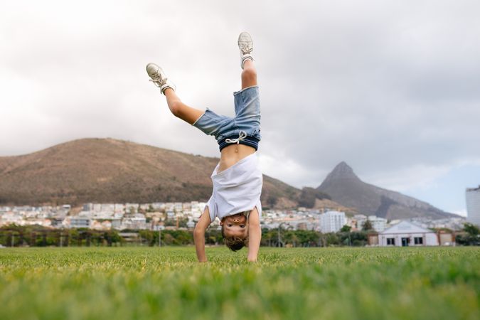Boy doing handstand in the park grass