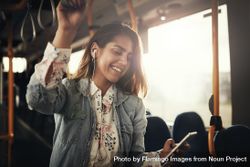 Woman smiling at phone on bus 5k1DWb
