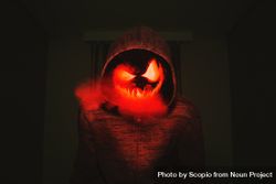 Person in hoodie with jack o lantern mask 4mKAe0