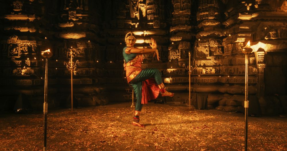 Portrait of an Active Female Indian Dancer Adorned in Traditional Attire inside an Ancient Temple.