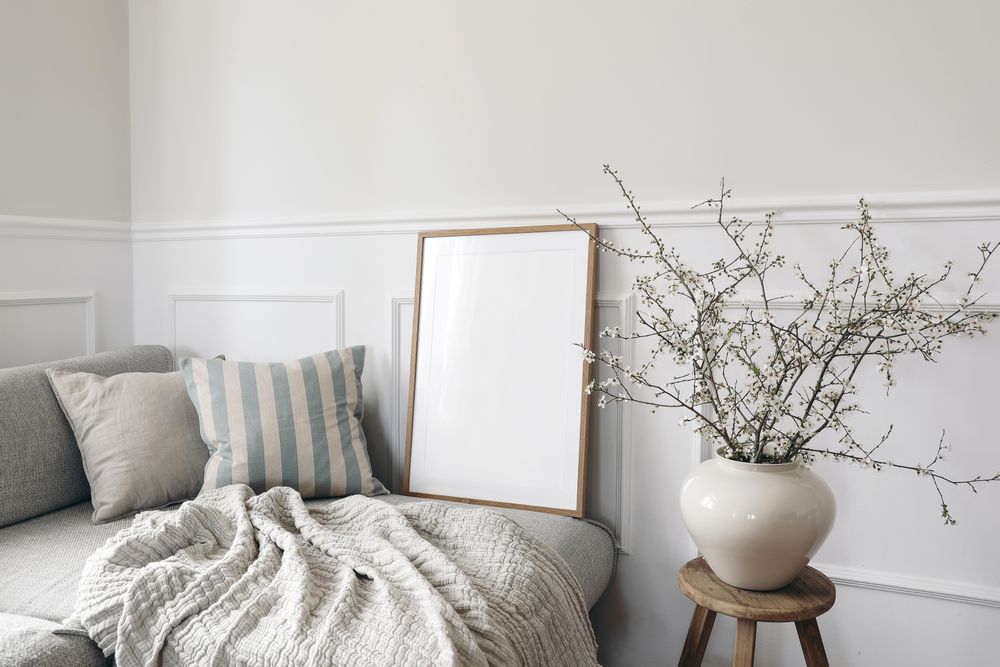 Neutral living room with vase and blooming cherry plum tree branches