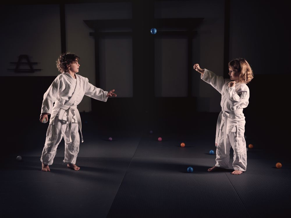 Kids practicing punches on balls during martial arts session
