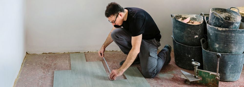 Bricklayer measuring tiles to install a floor